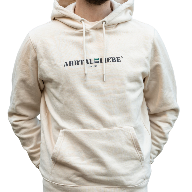 Beiger Hoodie mit schwarzem Aufdruck „AHRTALLIEBE seit 2021“ auf der Brust. Die Person trägt den Kapuzenpullover lässig mit den Händen in der Tasche; das Design wirkt modern, schlicht und heimatverbunden.