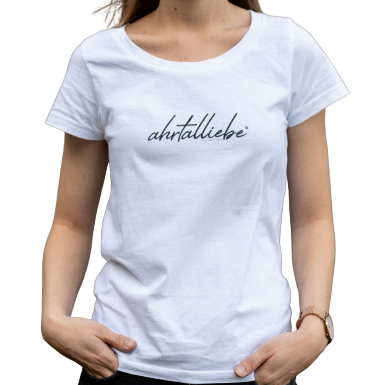 Weiße Damen-T-Shirt mit schwarzem Schriftzug „ahrtalliebe“ auf der Vorderseite. Die Person trägt das Shirt locker mit den Händen in den Hosentaschen; das Design wirkt schlicht, modern und drückt regionale Verbundenheit aus.